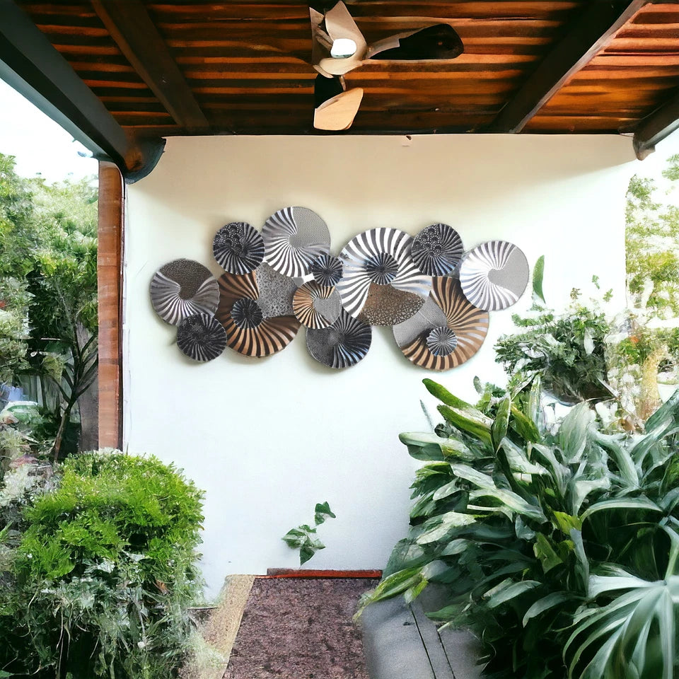 Circular metal wall sculpture with black, white and gold finish