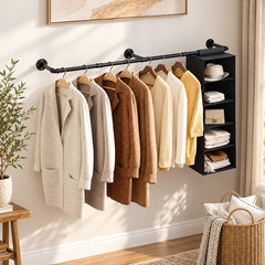 Black wall mounted pipe clothes rack with coats and sweaters on hangers and a hanging fabric shelf organizer at one end