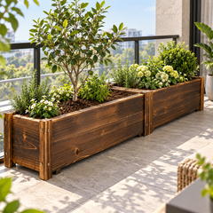 Two long wooden planter boxes on a balcony with a small tree, herbs and white flowers above a city view